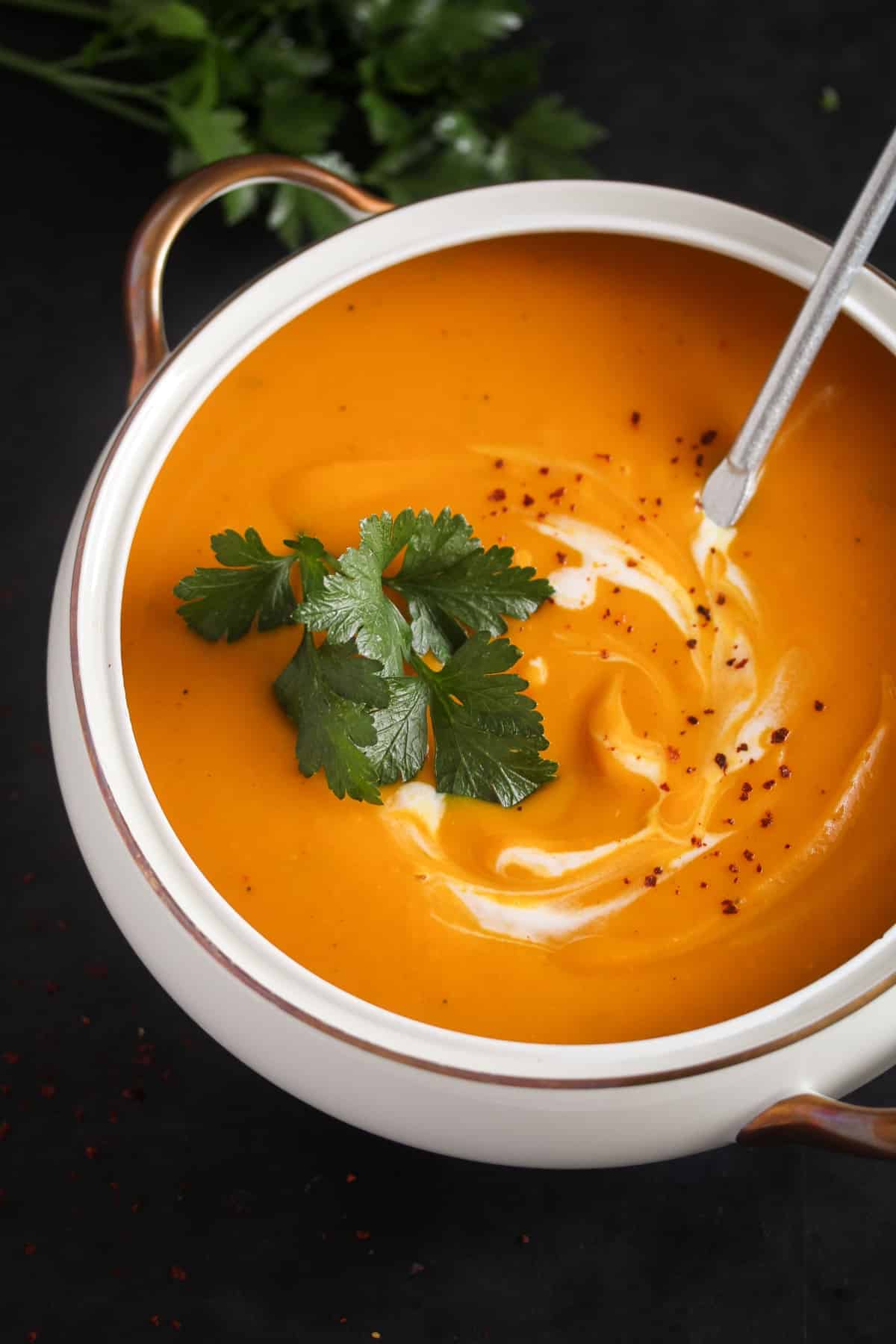 large bowl full of creamy soup with pumpkin.