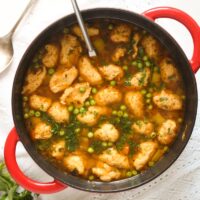 red dutch oven full of dumpling and vegetable soup.