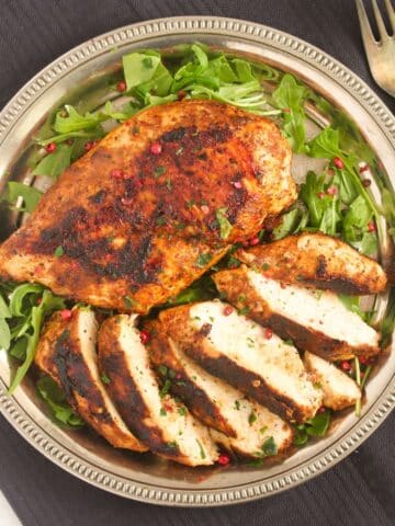 overhead view of pan-fried chicken breasts, one of them sliced.