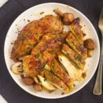plate with pan fried marinated chicken breasts, one sliced.