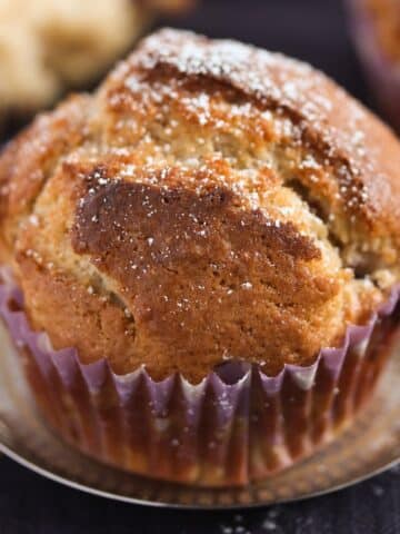one plum muffin on a small silver plate.