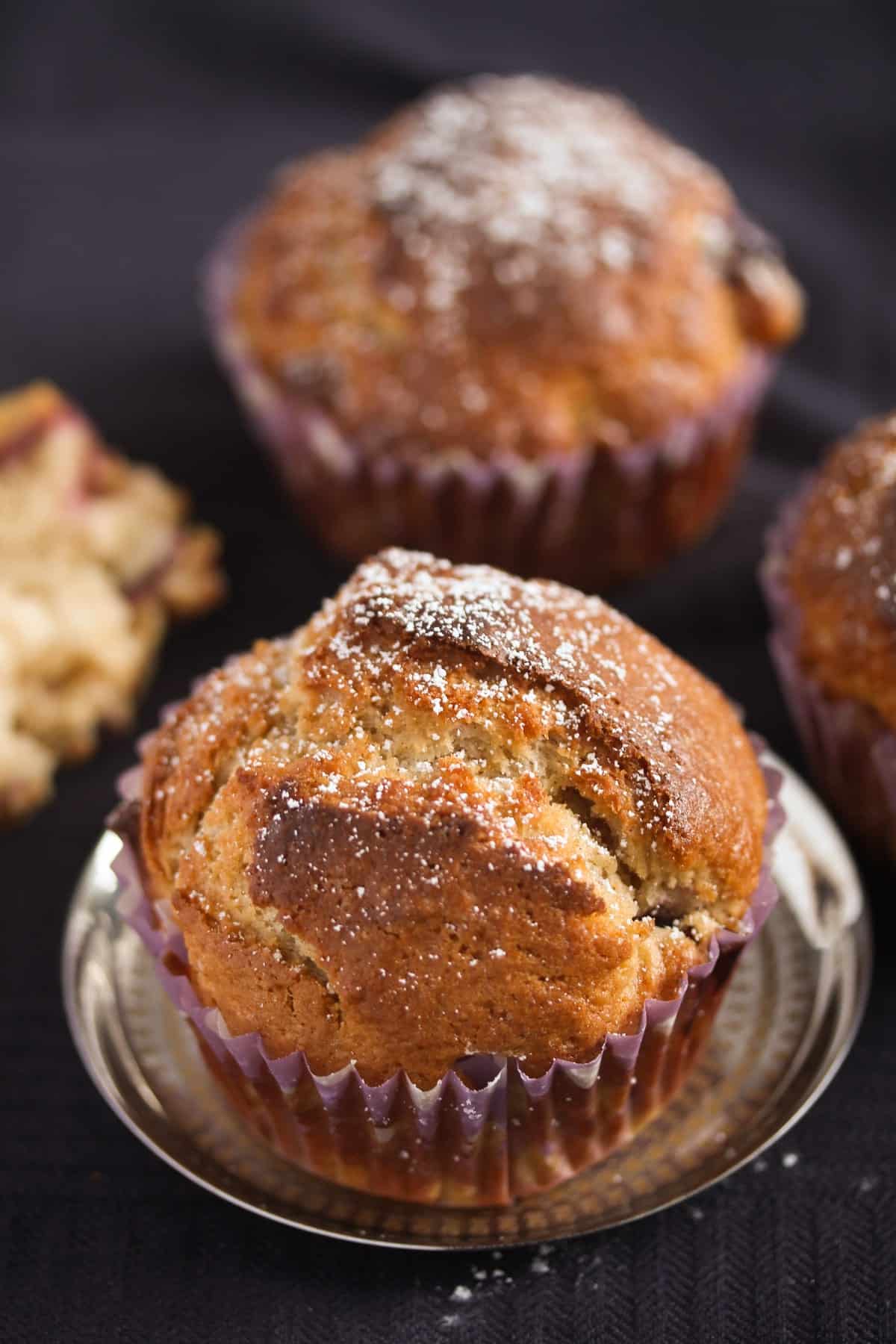 one muffin sprinkled with icing sugar on a small silver plate.