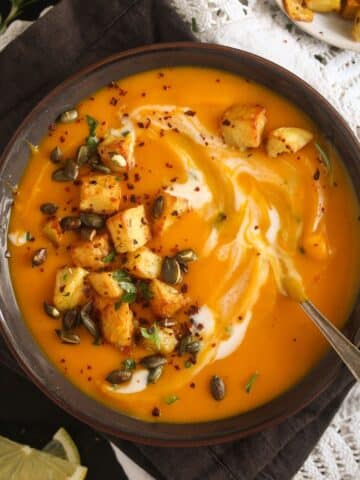 featured image of pumpkin and potato soup with pepitas, croutons and a swirl of cream.