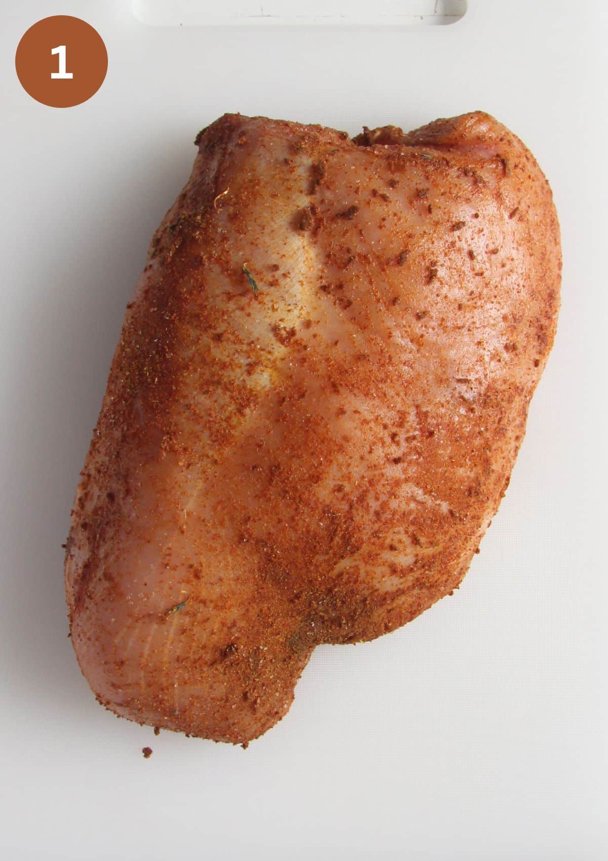 raw piece of seasoned turkey breast before roasting.