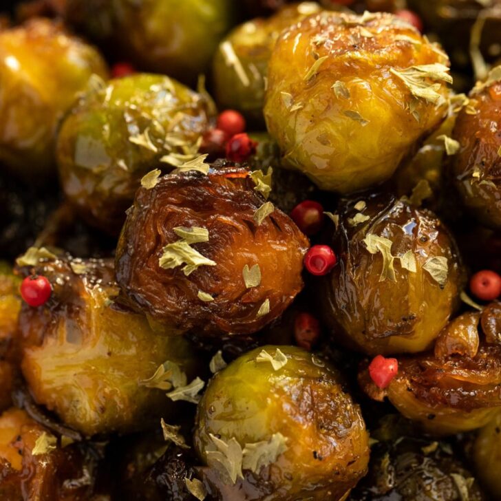 caramelized brussels sprouts sprinkled with red peppercorns close up.