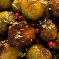 close up golden caramel sprouts with red peppercorns.