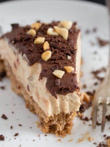 slice of peanut butter pie sprinkled with chocolate and peanuts on a plate.