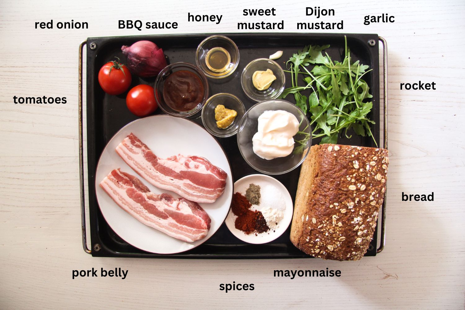 listed ingredients for pork belly sandwich on a large baking sheet.