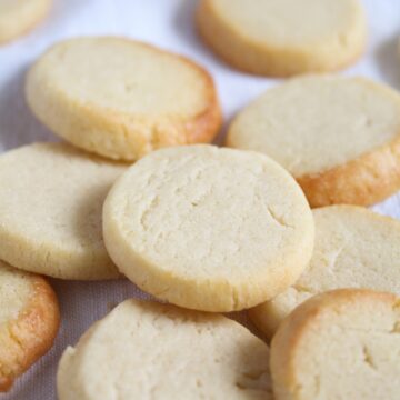 many round biscuits with sweetened condensed milk on the table.