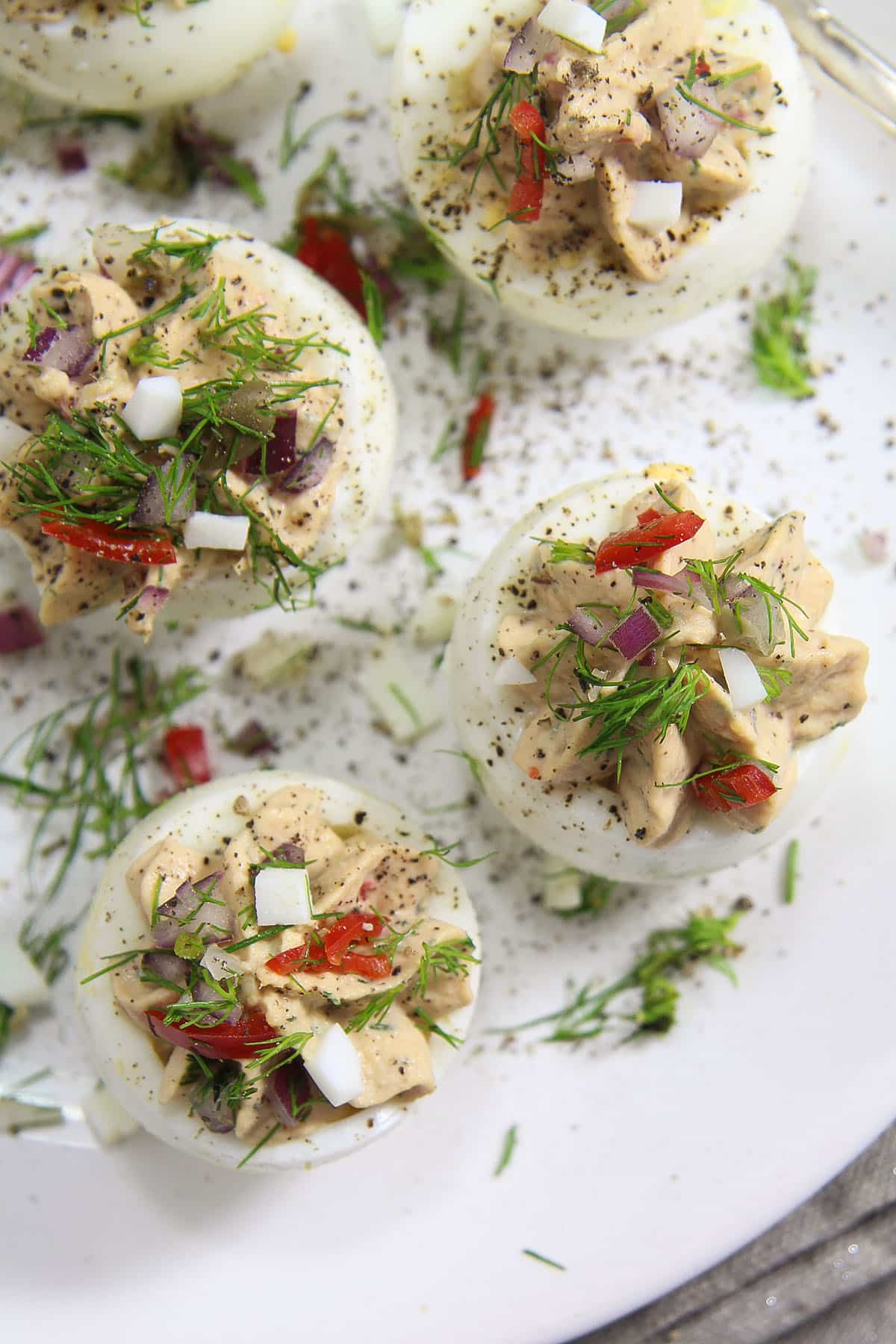 stuffed eggs with tuna filling on platter.