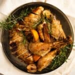 crock pot whole turkey carved on a vintage platter with rosemary.