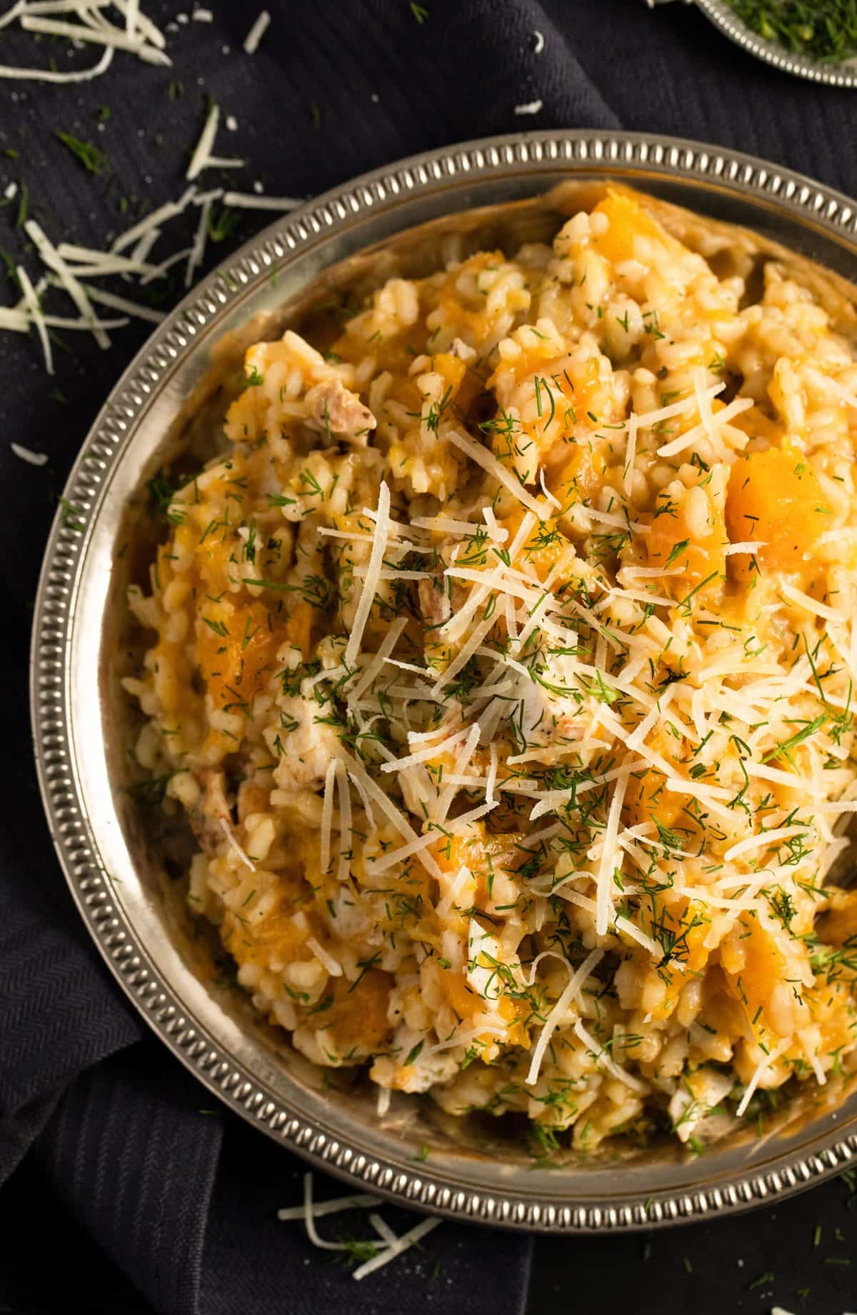 arborio rice with roasted pumpkin, parmesan and chicken on a silver plate.