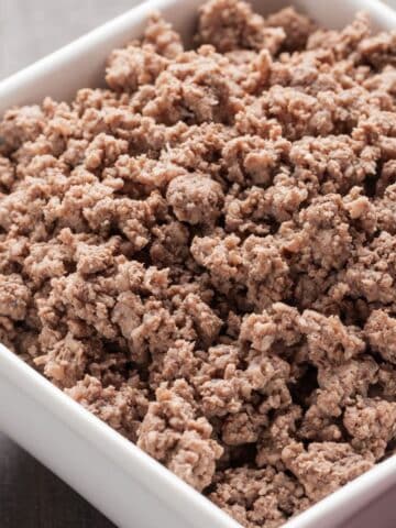 frozen ground beef cooked in the instant pot in a white bowl.