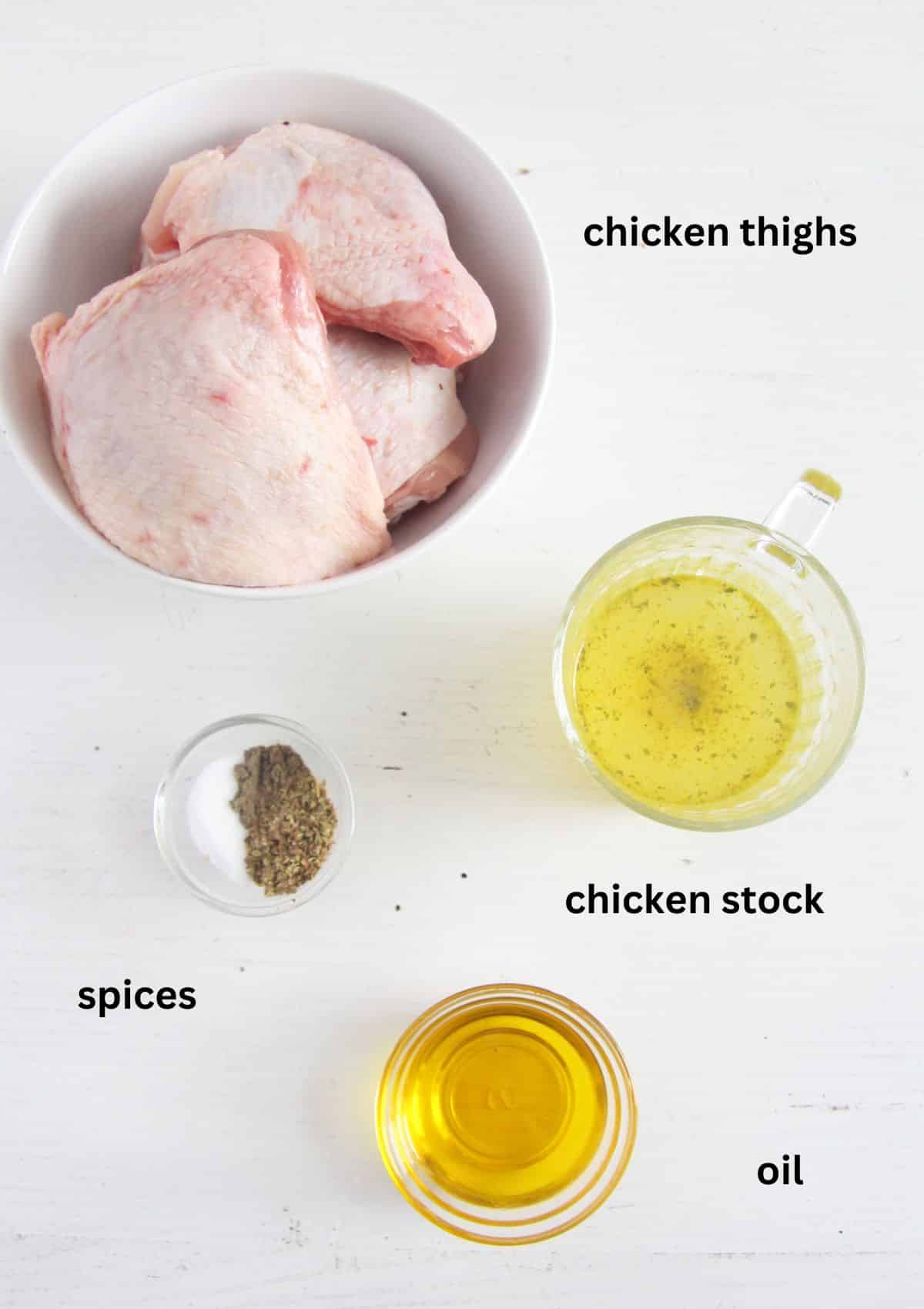 raw chicken pieces, oil, spices and stock in bowls.