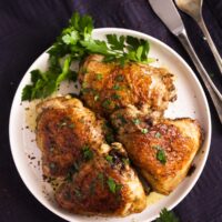 small plate with chicken portions on a plate on a black cloth.