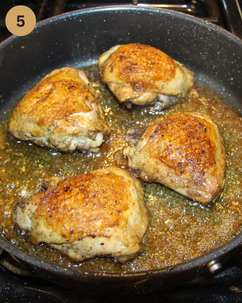 golden pan-seared chicken thighs in a nonstick pan.