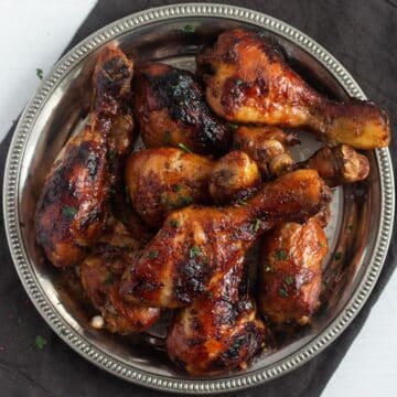 overhead view of a silver platter full of golden brown slow cooker chicken legs.