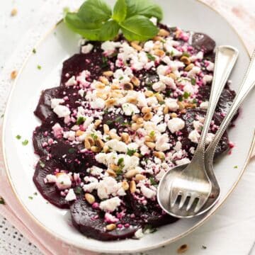 vintage platter with beetroot feta salad with a fork and spoon.