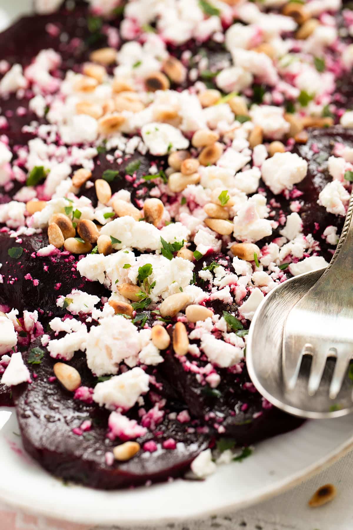 roated beetroot salad with cheese and nuts close up on a plate.
