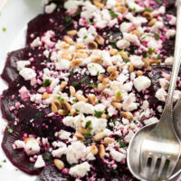 close up beet and feta salad with balsamic, basil and pine nuts.