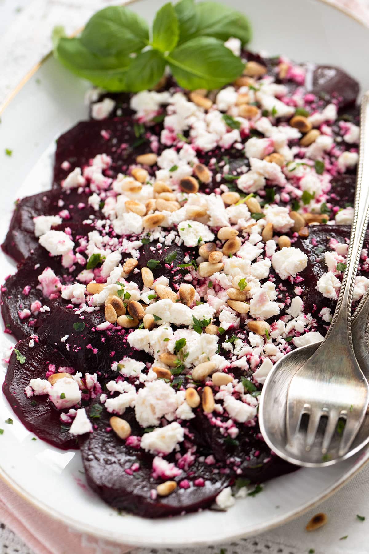 close up beet and feta salad with balsamic, basil and pine nuts.