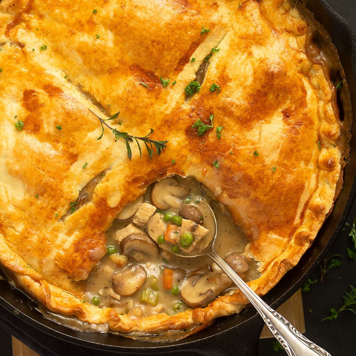 chicken pot pie in the cast iron skillet showing the creamy filling.