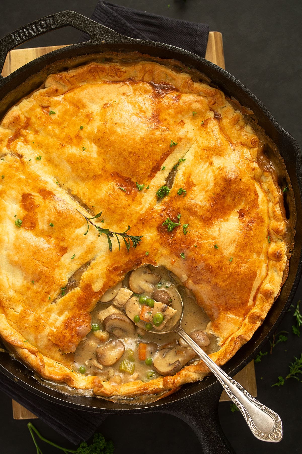 pot pie showing the creamy filling with a spoon in it.