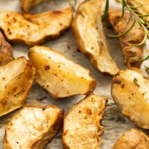 cooked jerusalem artichokes and a sprig of rosemary close up.