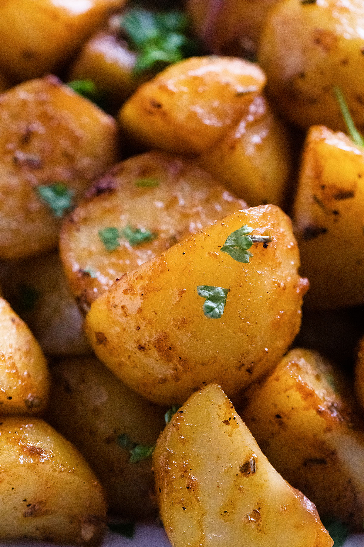 close up chunky potato pieces roasted in crock pot and sprinkled with parsley.
