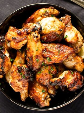 overhead view of a bowl with baked spicy chicken wings.
