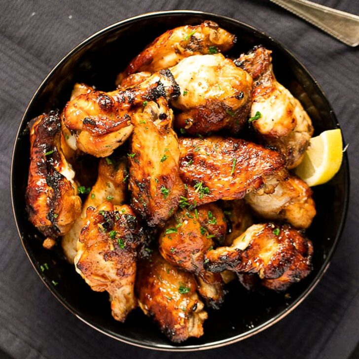 overhead view of a bowl with baked spicy chicken wings.