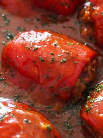 stuffed peppers with ground meat in tomato sauce close up.