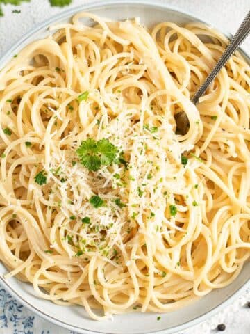 overhead view of a bowl of tangled truffle butter pasta sprinkled with parsley.