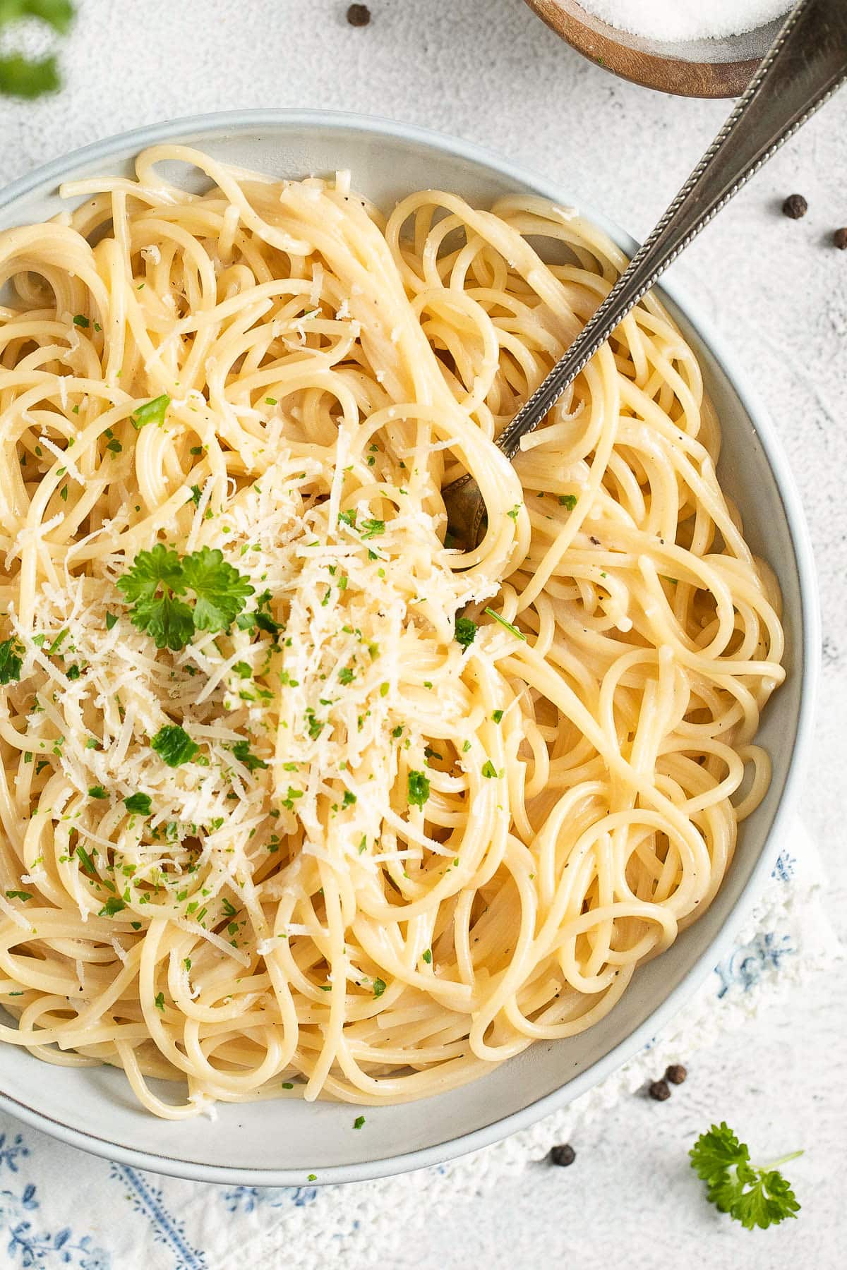 close up bowl of spaghetti with black truffle butter sauce and a fork sticking in it.