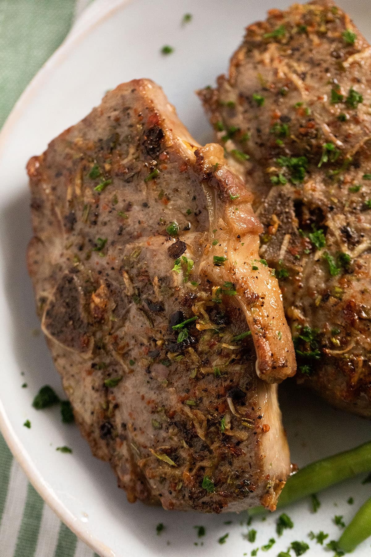 close up two lamb chops sprinkled with parsley.