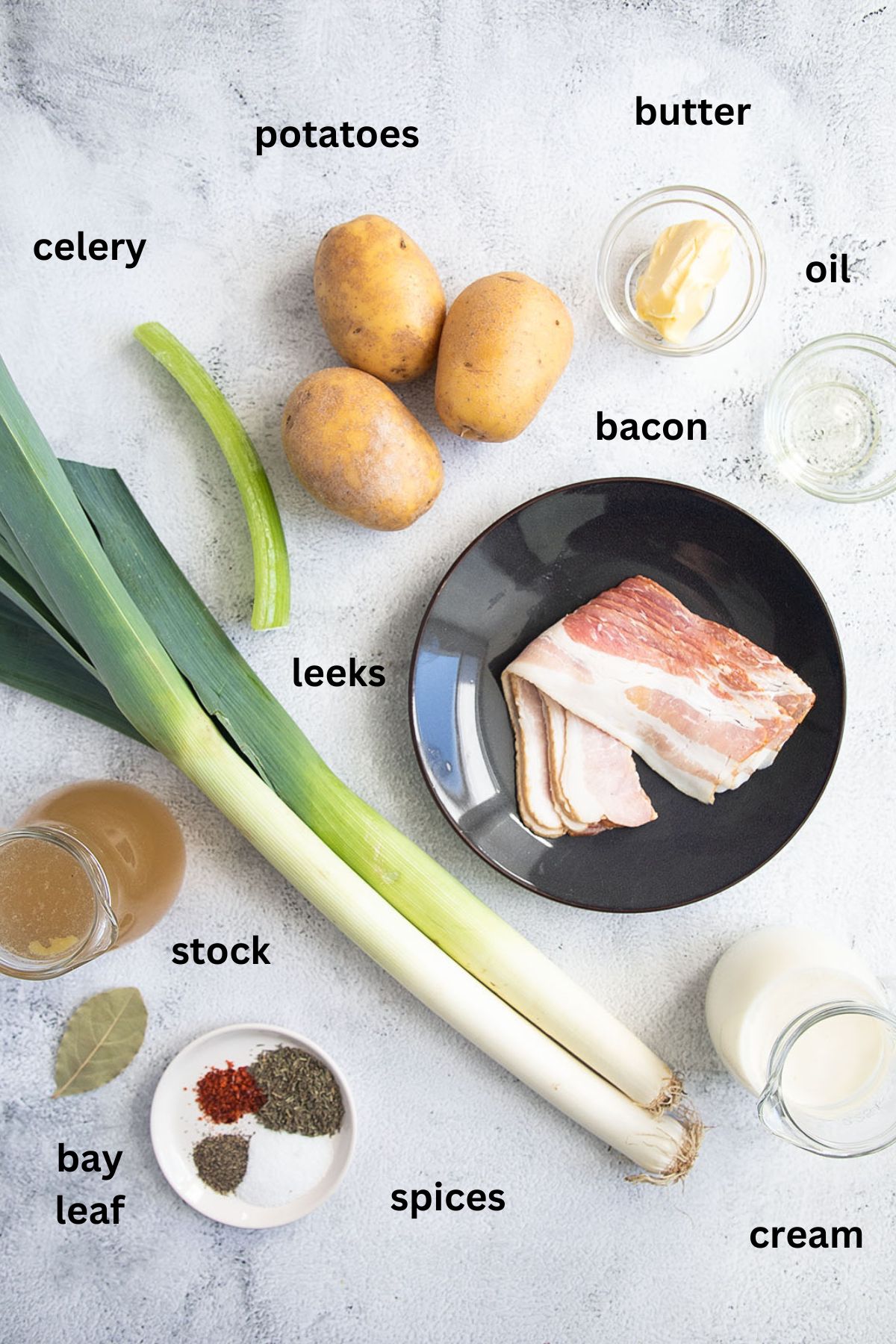 listed ingredients for making leek and potato soup with bacon arranged on the table.