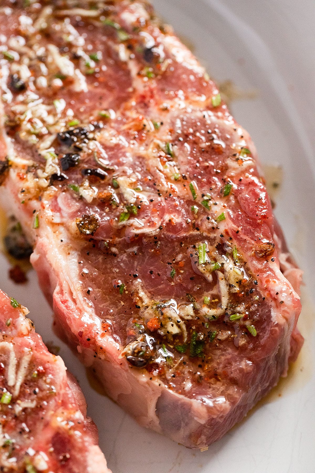 raw lamb chop marinated with garlic and rosemary.