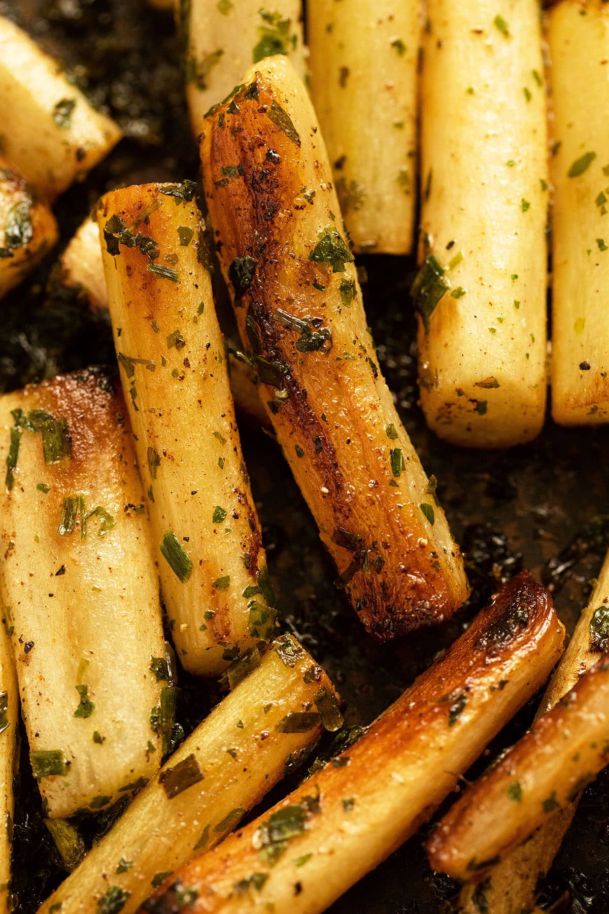 close of pan fried golden brown salsify sprinkled with parsley.