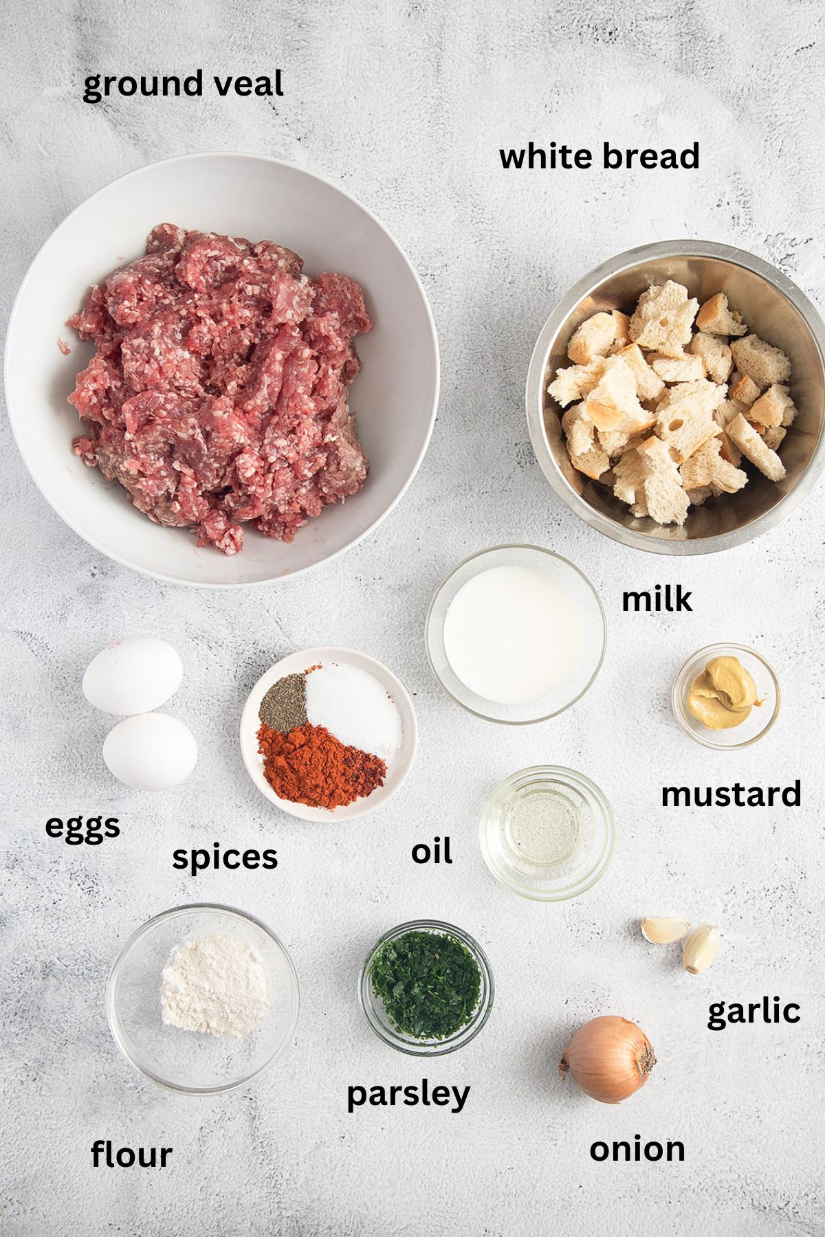 listed ingredients for making meatballs with ground veal, white bread, eggs and spices.