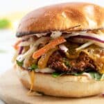 pinterest image of a burger with chicken fillet and coleslaw.