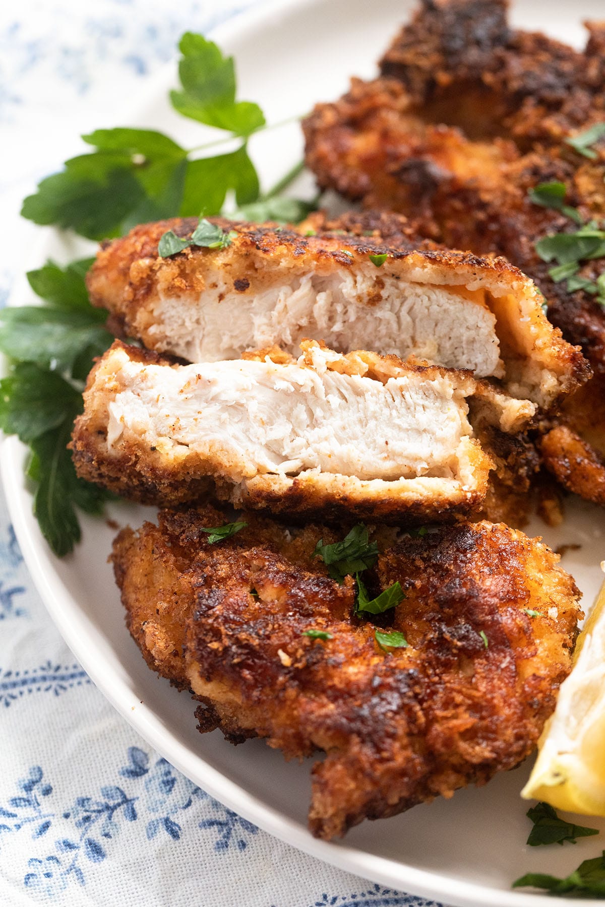 close up of a sliced breaded chicken piece showing the white meat.
