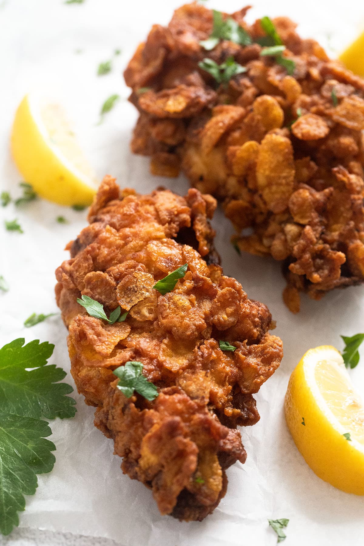 two chicken pieces fried in a cornflake coating.