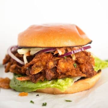 crispy chicken burger with coleslaw, lettuce and red onions.