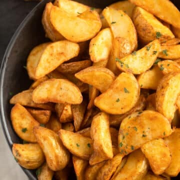 a bowl of golden potato wedges cooked in the air fryer.