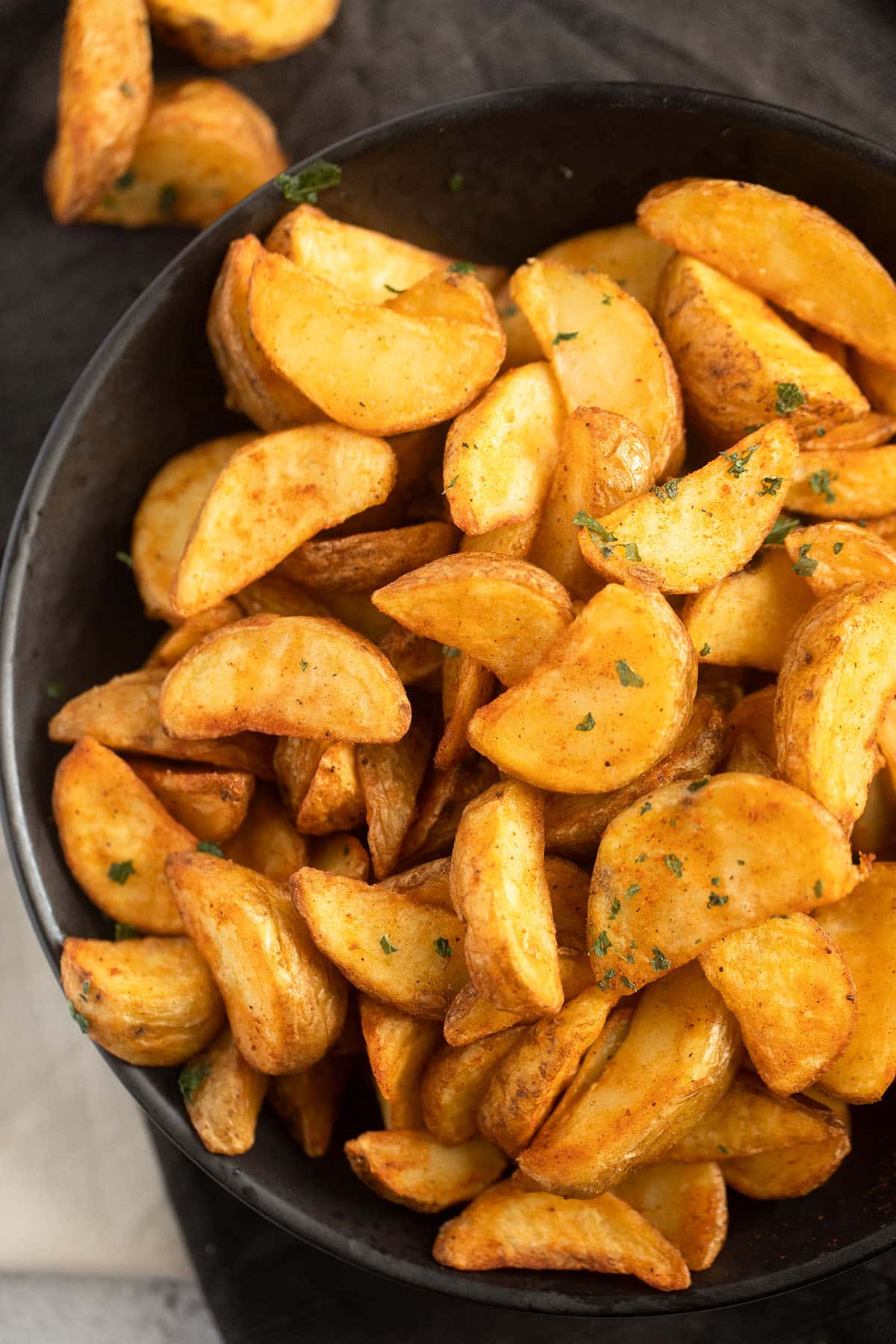 a bowl of golden potato wedges cooked in the air fryer.