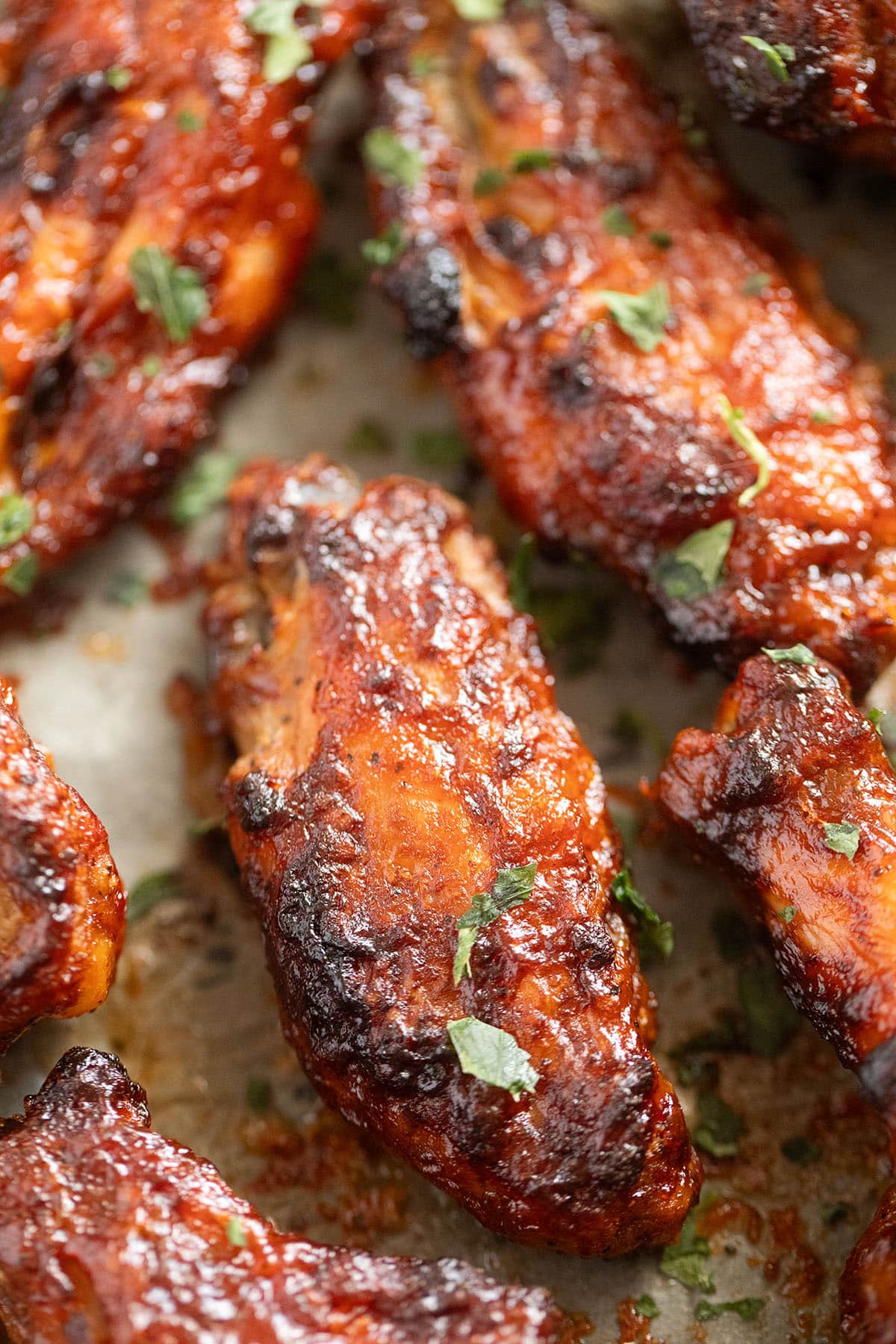 close up of barbecue chicken wings sprinkled with parsley.