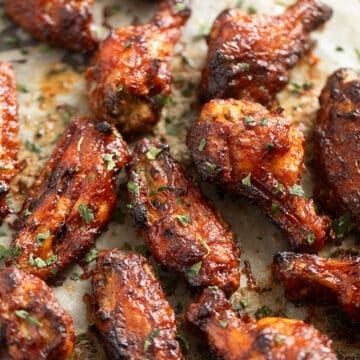 many baked bbq wings on a baking sheet.