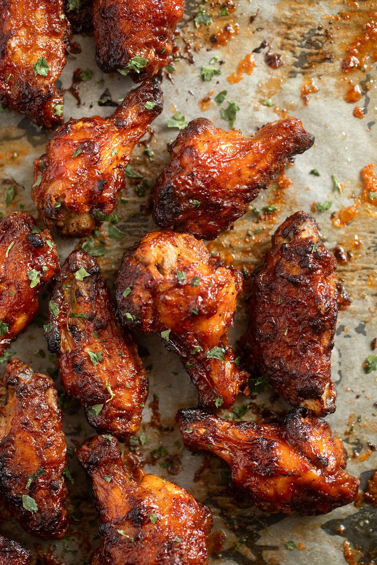 chicken wings glazed with with barbecue sauce on a baking tray.
