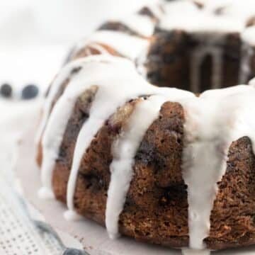 close up of blueberry sour cream bundt cake glazed with icing.
