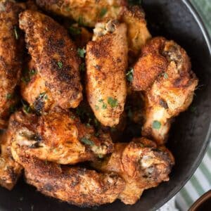 many extra crispy cornstarch chicken wings in a black bowl.